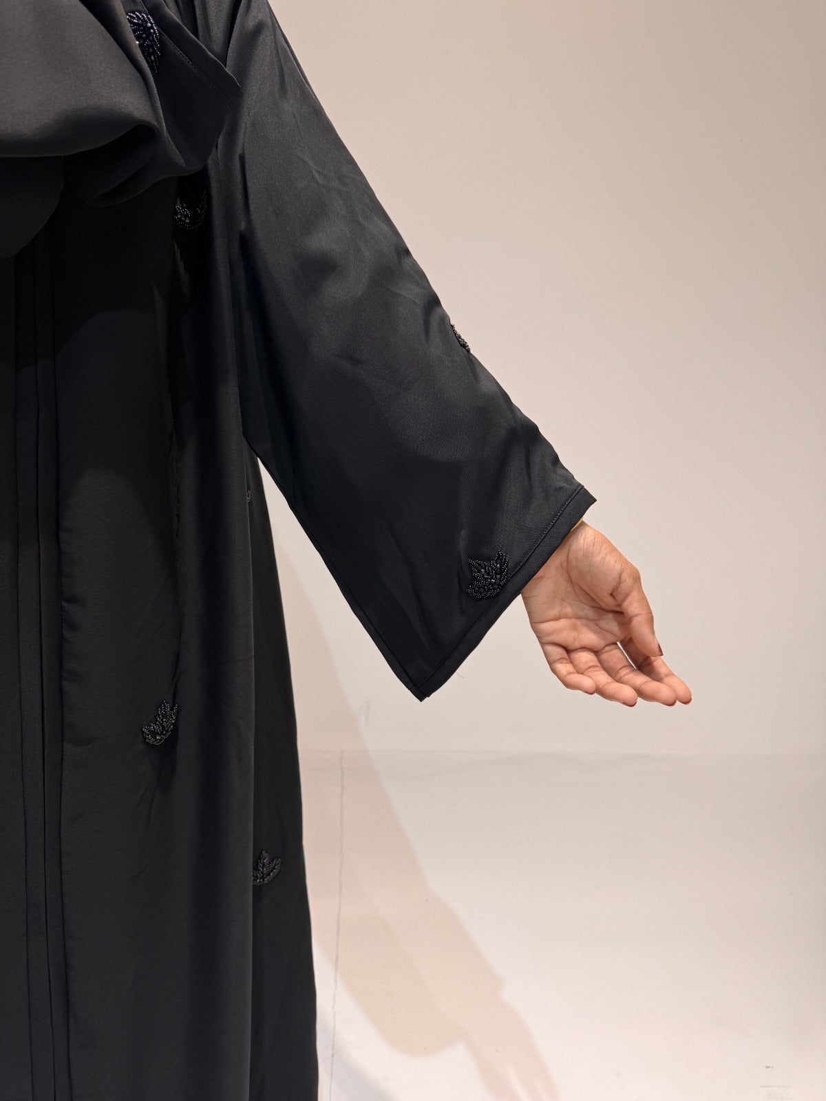 Front-open black abaya with handcrafted bead embellishments and wide sleeves